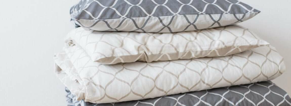 スツールの上に積み重ねられたグレーと白の枕。 (キーワード:枕)