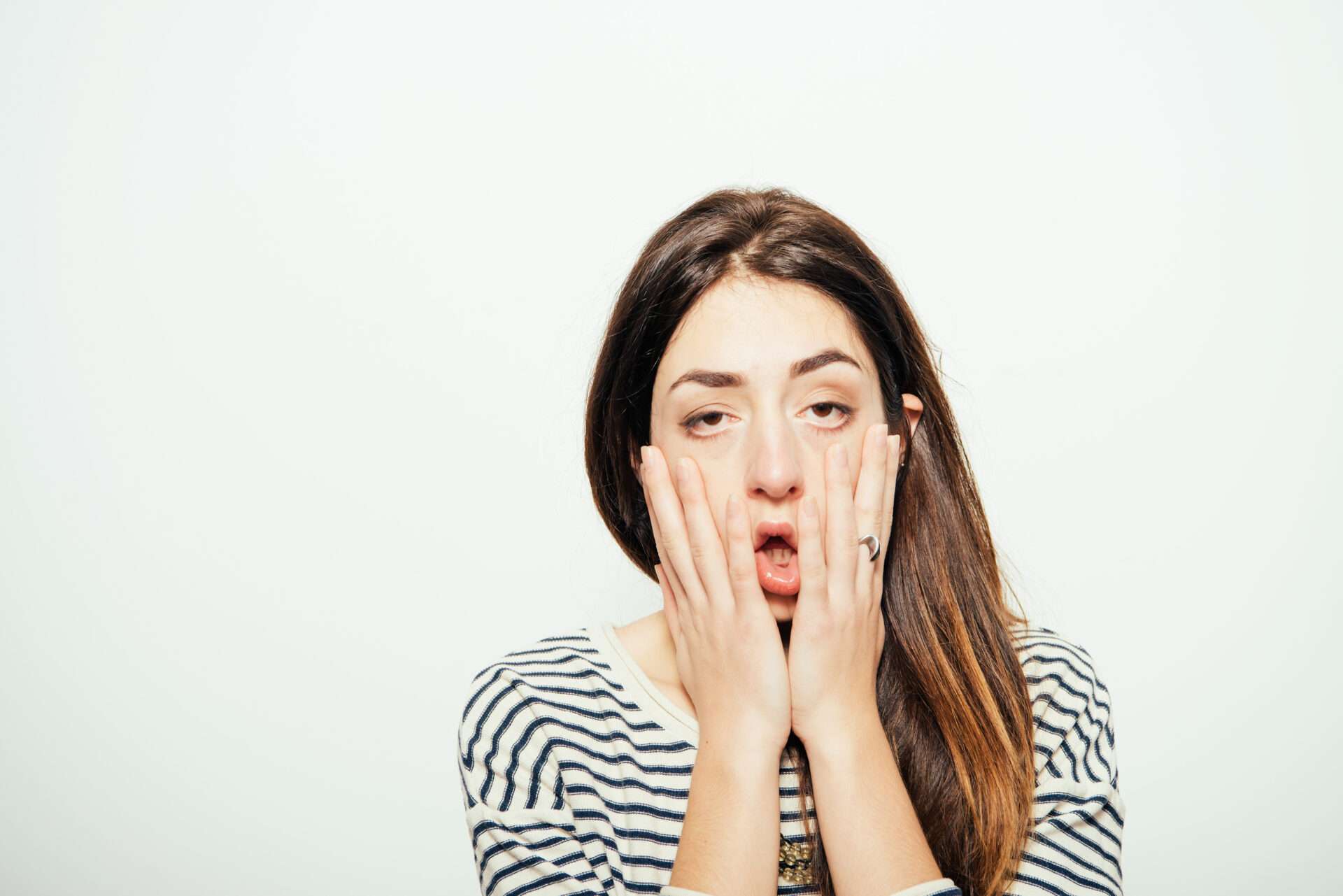 手で顔を覆う女性。