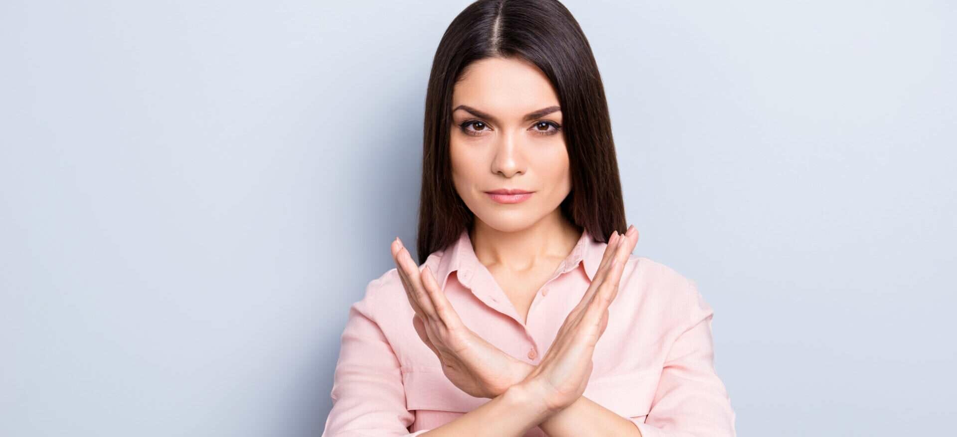 手で一時停止の標識を作る若い女性。