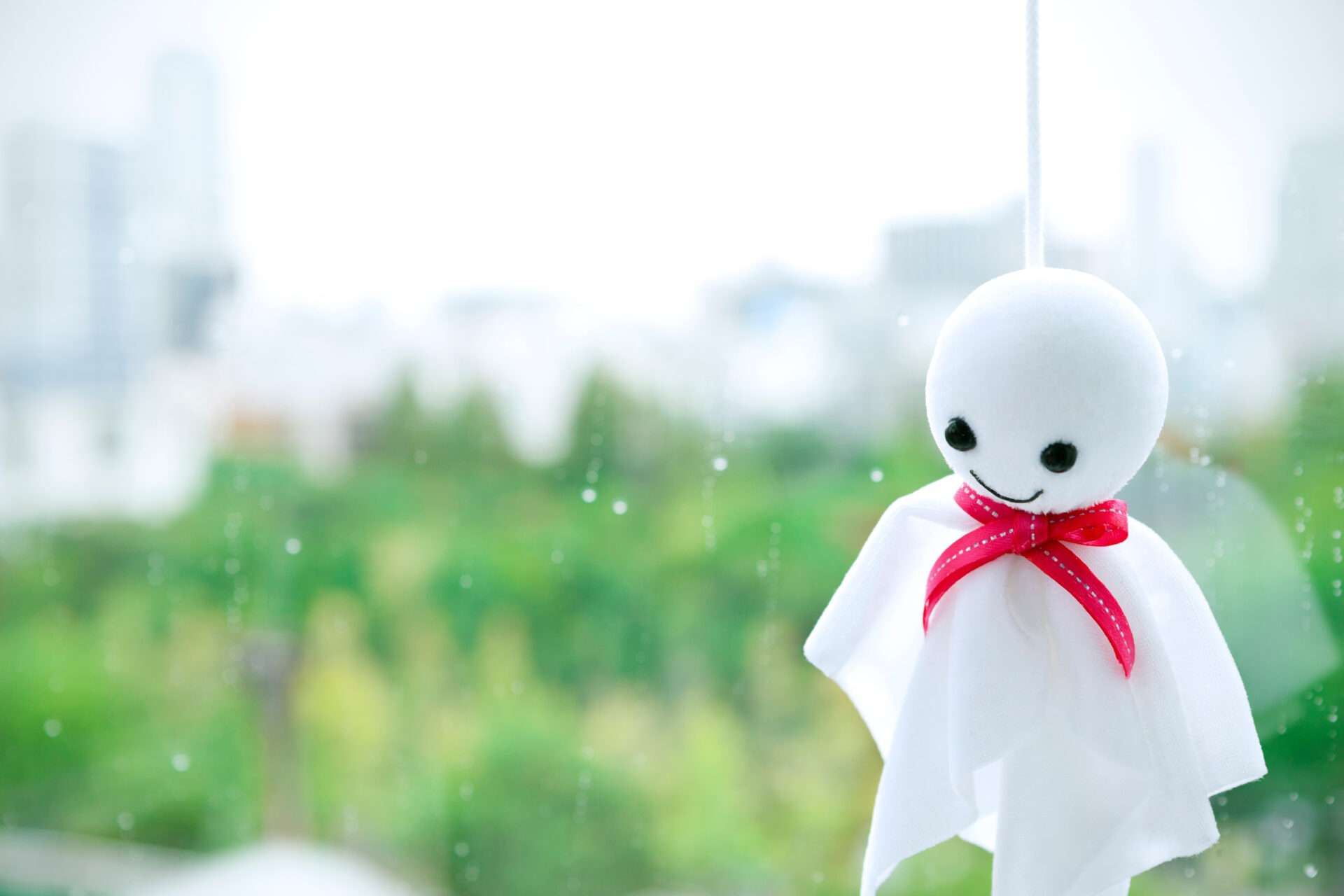 赤いリボンを巻いた白い幽霊が窓に浮かんでいる。