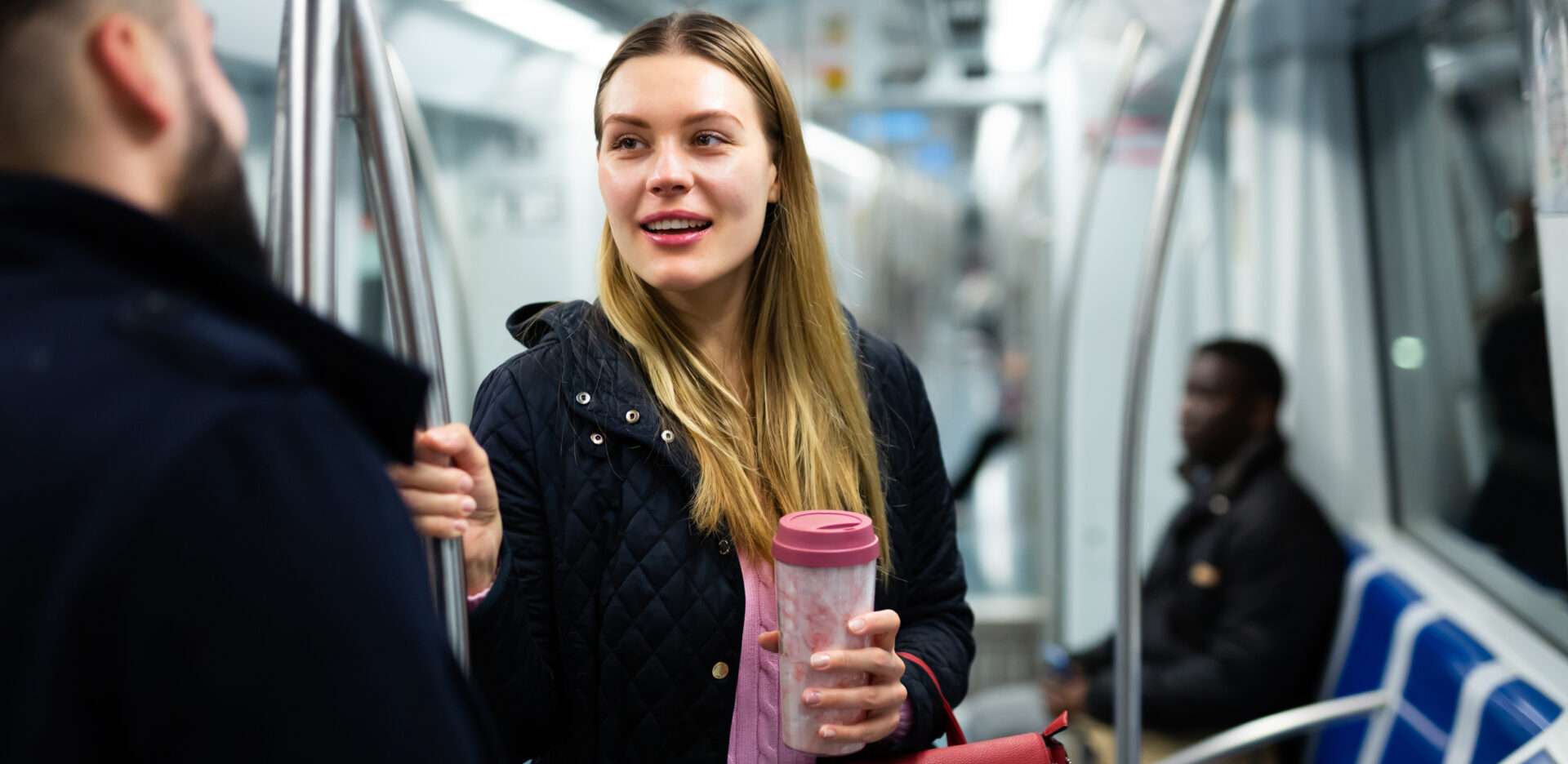 地下鉄の中で英語で会話する男女。