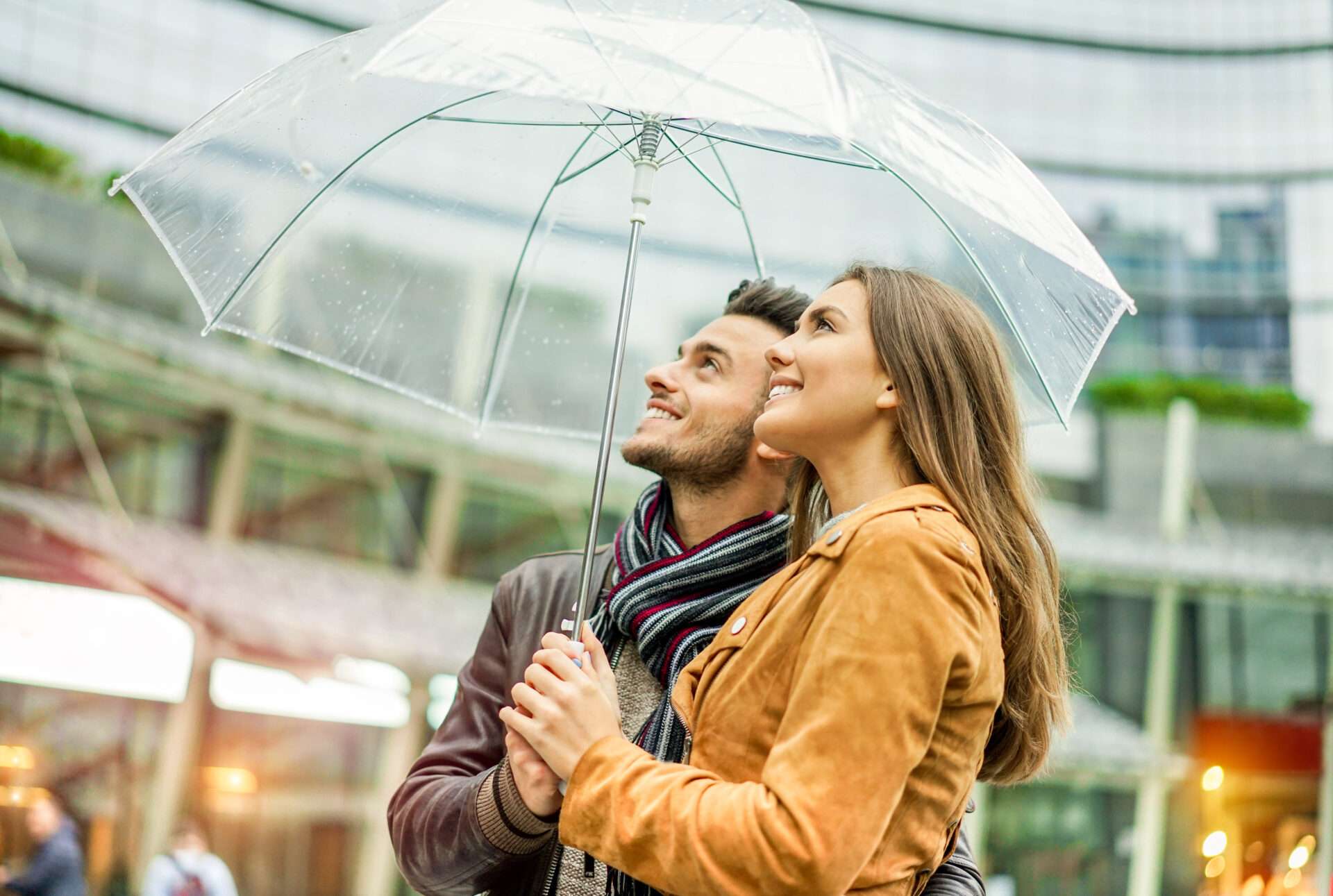 街中で傘をさす男女。 （英語）