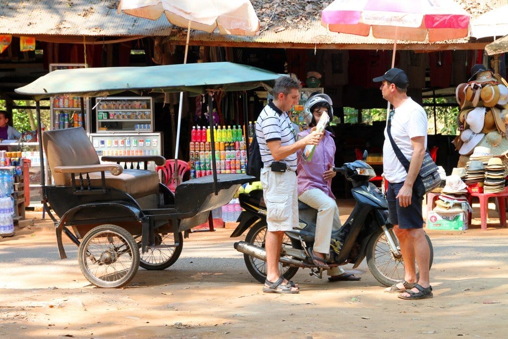 男性が人力車の横に立って英会話をしている。