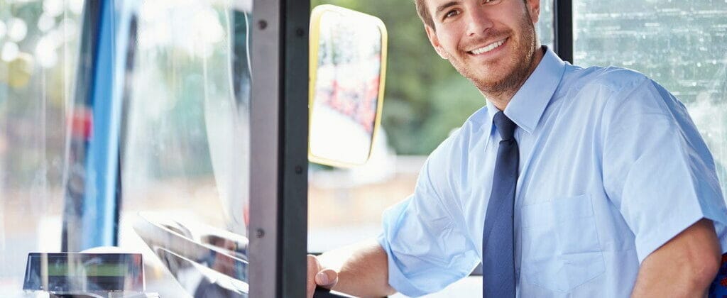バスの運転席に座って英語で英会話の練習をしている男性。