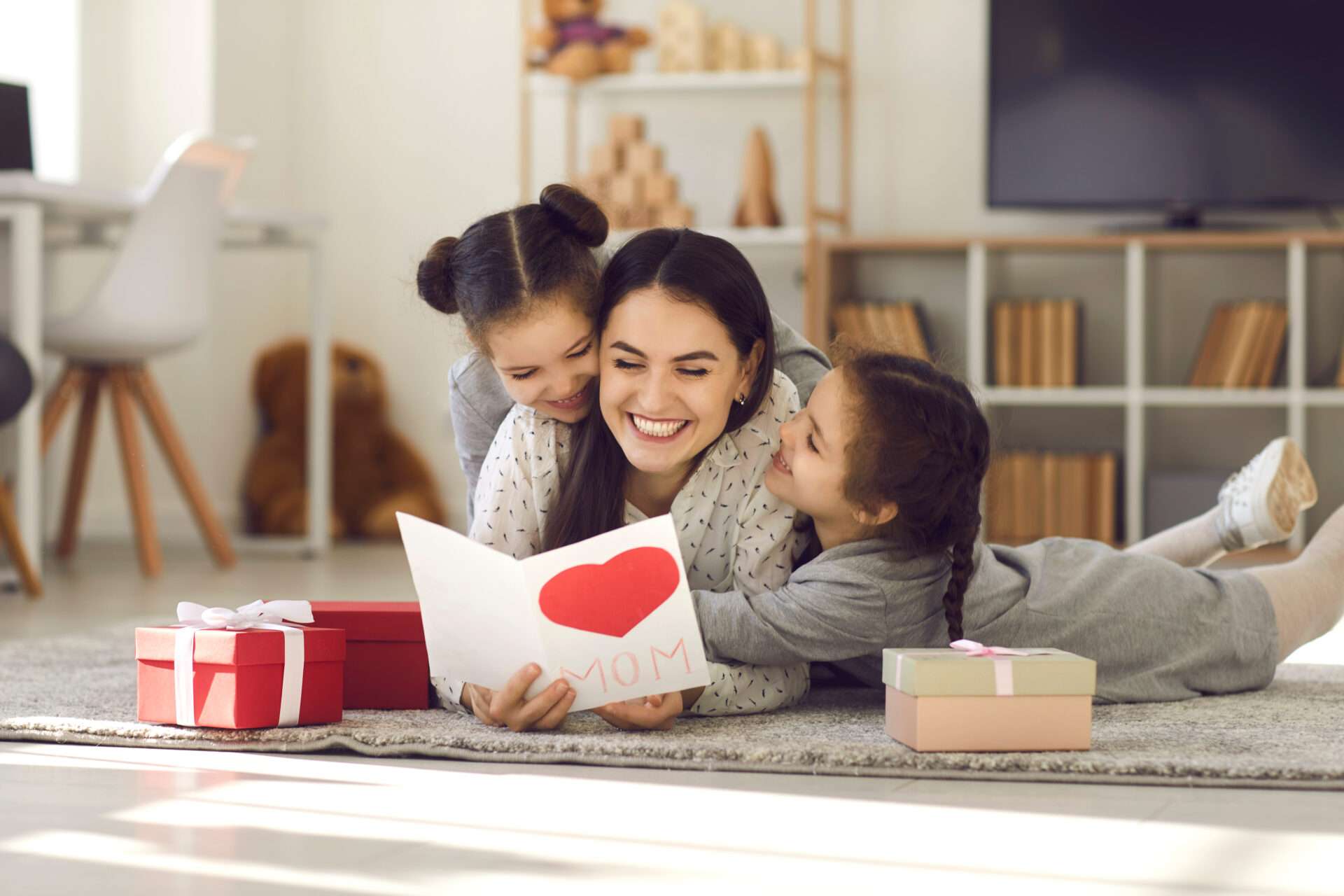 英語で子供たちにバレンタインデーのカードを読み聞かせる母親。