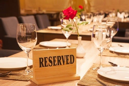 英会話教室のテーブルの上に、赤いバラが描かれた木の看板が置かれています。