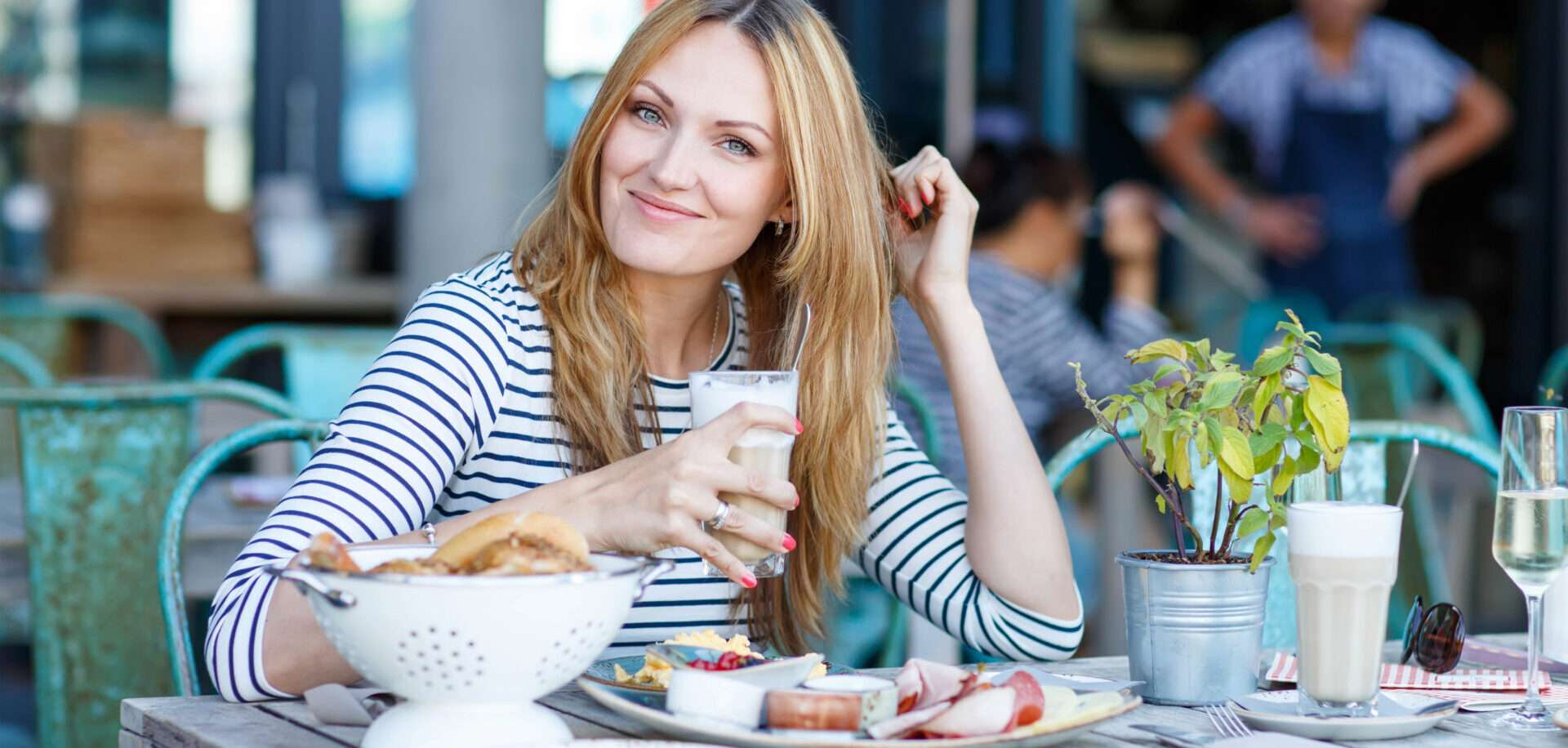 屋外のテーブルに座ってワインを飲みながら英語を話す女性。