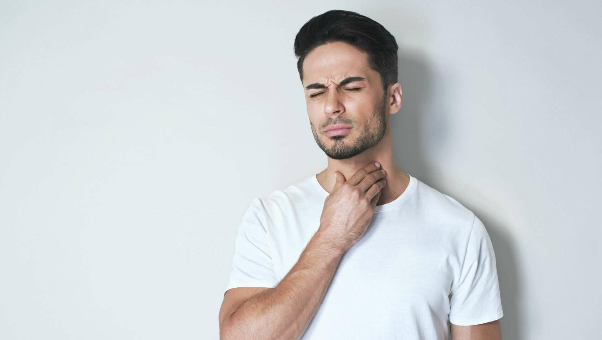 男性が英語で首を手で触っています。