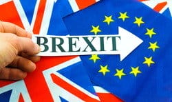 「Brexit」という言葉が書かれた紙を持った手は、英語への影響を強調し、英会話のクラスでの議論を引き起こします。