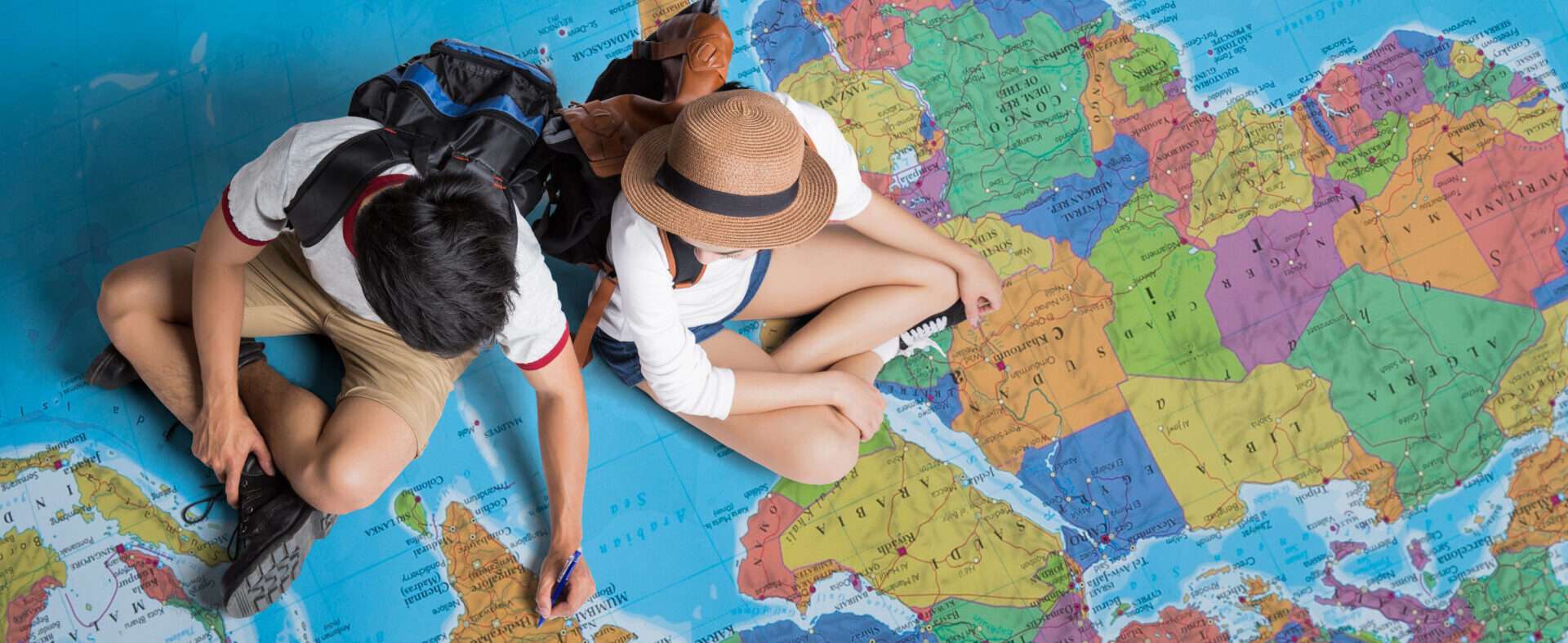 地図の上に座って勉強している 2 人。 地図の上に座って勉強している 2 人。