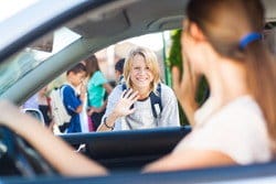 車に乗っている女の子が、車内で別の女の子に手を振りながら日本語で会話しています。