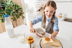 女の子がキッチンで朝食の準備をしながら、英会話の練習をしたり、日本語のポッドキャストを聞いたりしています。