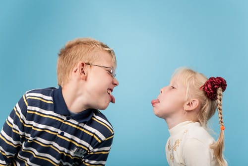 青い背景に男の子と女の子が英語で熱く議論しています。