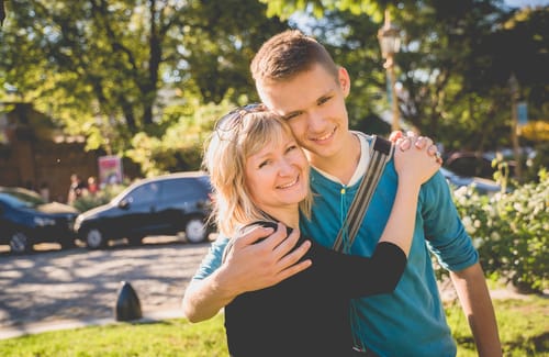 公園で抱き合いながら英語で話す男女。