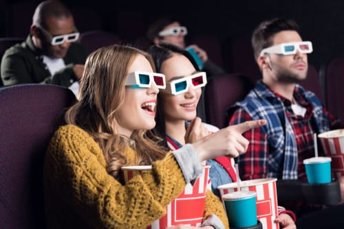 3D メガネをかけて映画館に座っている人々のグループ。