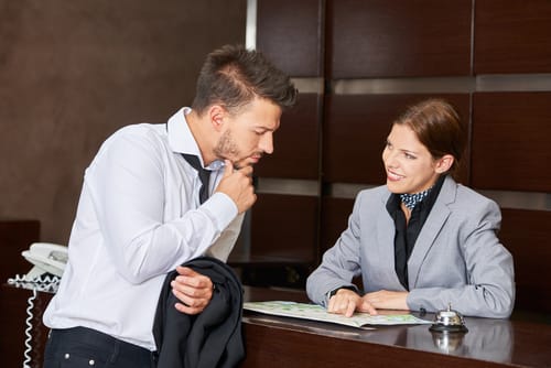 受付で英会話をする男女。