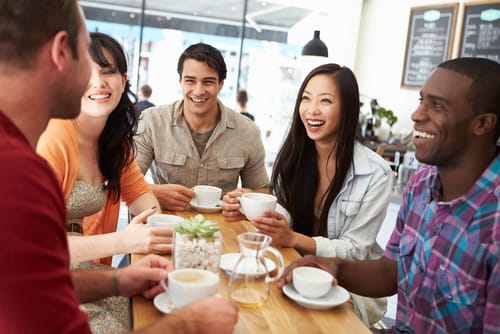 日本語の英会話グループがテーブルに座ってコーヒーを飲んでいます。