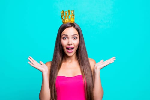 頭に王冠をかぶったピンクのドレスを着た若い女性が英語を話しています。