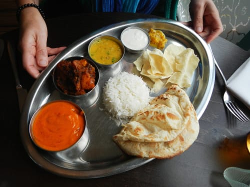 食べ物の皿を持った人が英会話の会話をしています。