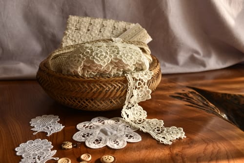 英会話の練習に使用される木製のテーブルに置かれたレースとボタンのバスケット。