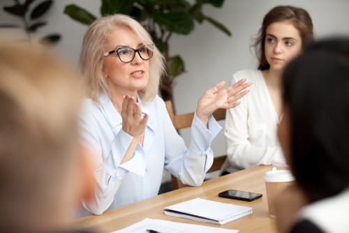 テーブルに座り、活発な英会話会話をしている女性のグループ。