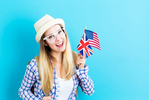 アメリカの国旗を持ち、英会話に取り組む若い女性。