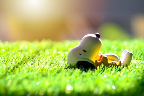 日本語 草の上に横たわるおもちゃのスヌーピー。