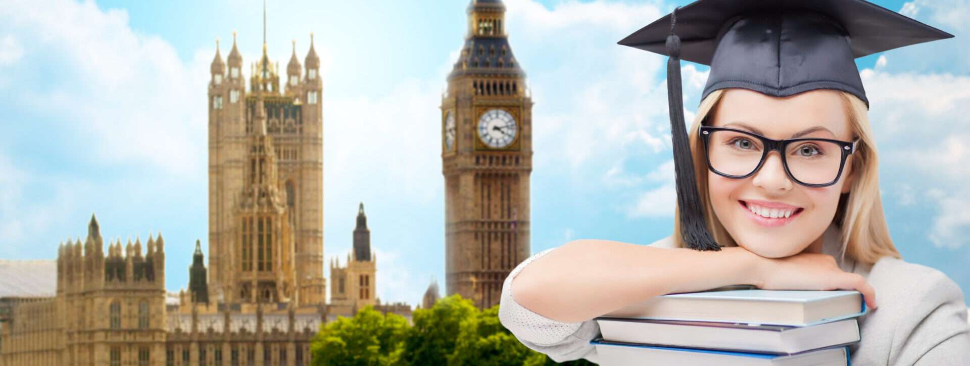 卒業式の帽子とガウンを着た女の子が、ビッグベンの前で本を抱えて自分の功績を祝っています。