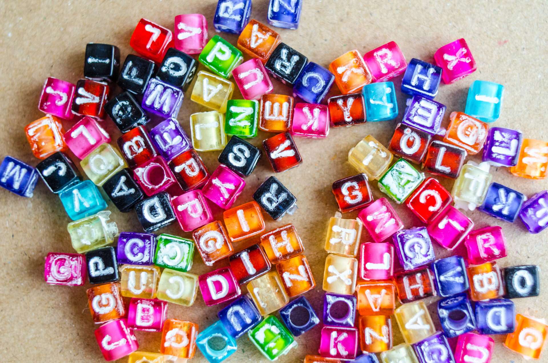 テーブルの上に円形に並べられたカラフルなアルファベットビーズ。