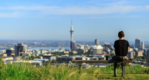 ベンチからオークランドの景色を楽しみながら英会話を楽しむ女性。