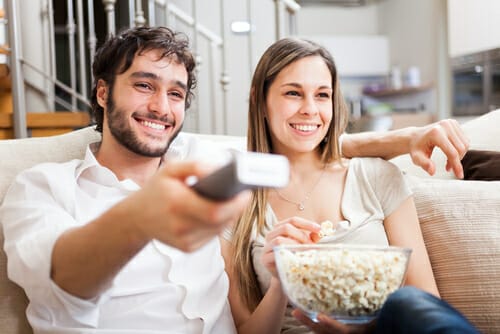 ソファでテレビを見ている男性と女性。