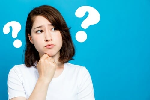 頭の上に疑問符が付いた若い女性は混乱しているように見えます。