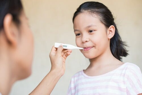 小さな女の子が母親から日本語の体温計をもらっています。