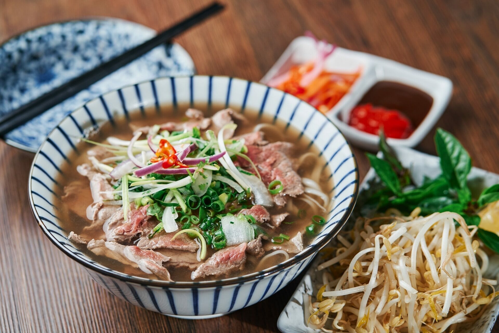 日本語の木製テーブルの上に牛肉麺のスープが入ったボウル。