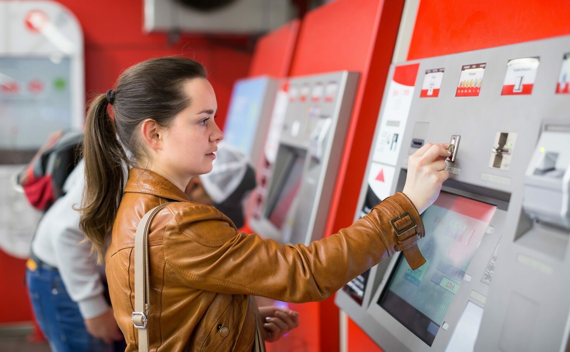 女性が ATM 機を操作しています。