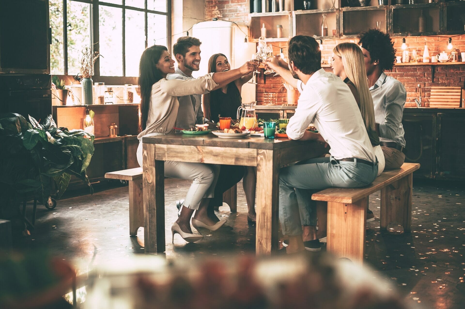 レストランのテーブルで飲み物を楽しむ人々のグループ。 レストランのテーブルで飲み物を楽しむ人々のグループ。