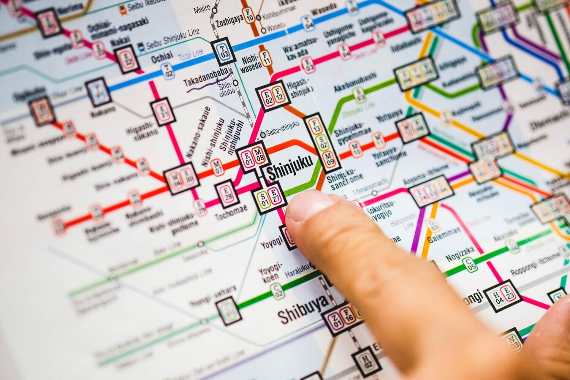英語で書かれた公共交通機関の地図を指差している人。