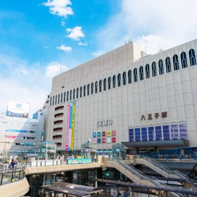 日本の八王子駅は、近代建築の驚異と澄み切った青空を背景に、賑やかな歩行者専用エリアが特徴です。.