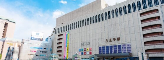 日本の八王子駅は、近代建築の驚異と澄み切った青空を背景に、賑やかな歩行者専用エリアが特徴です。.