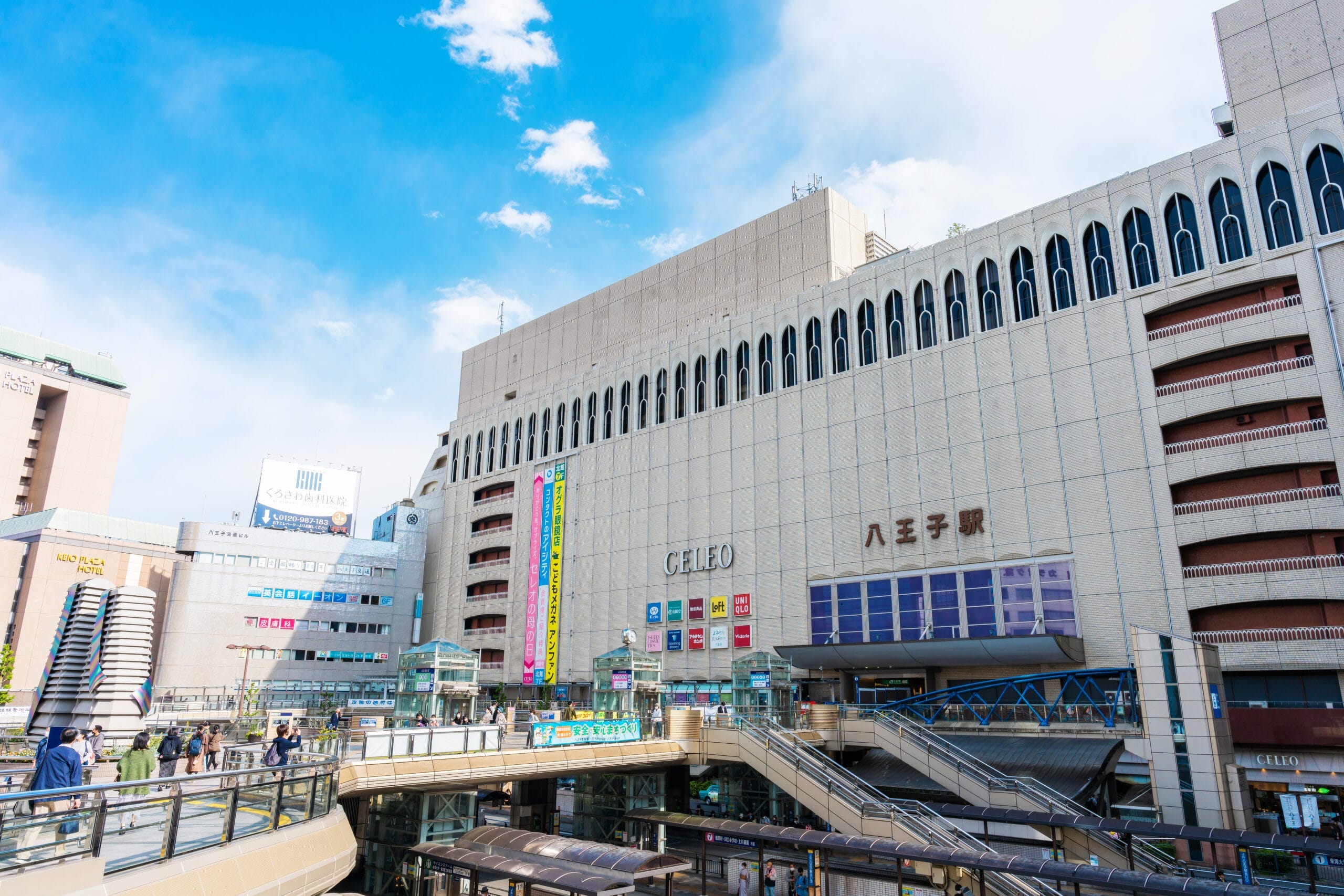 日本の八王子駅は、近代建築の驚異と澄み切った青空を背景に、賑やかな歩行者専用エリアが特徴です。.