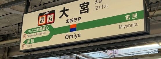 駅の案内板には、さいたま新都心と浦和行きのプラットホームの横に、日本語、韓国語、英語で大宮行きの案内が表示されている。周囲には駅の屋根構造が残されている。.