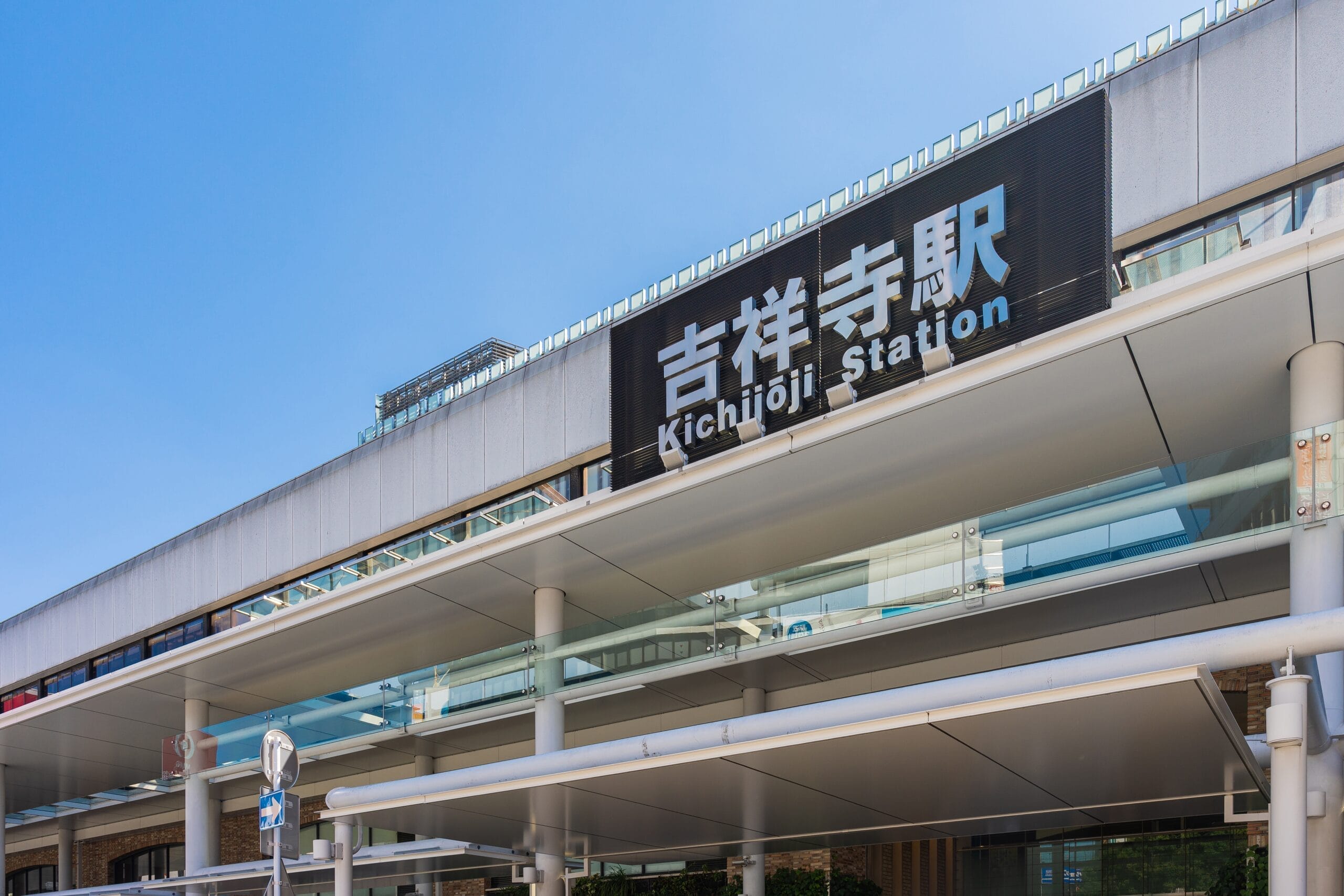 画像は晴天の下、吉祥寺駅の入口を捉えたもので、駅名が日本語と英語で大きく表示されている。すぐ近くにある英会話マンツーマン クラスは、すべての人にパーソナライズされた学習の機会を提供します。.