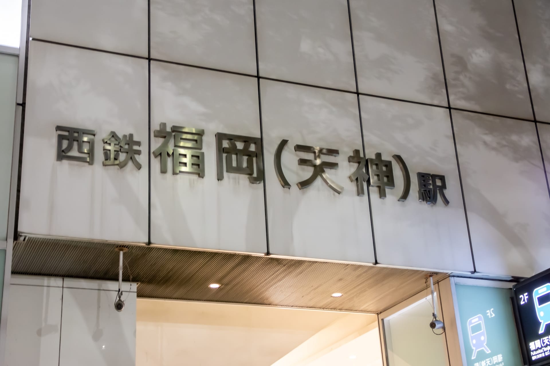 福岡市のビルの外観には、駅の入り口に日本語の文字が描かれています。近くの英会話スクール マンツーマンでは、外出中の人向けに個別の英語レッスンを提供しています。.