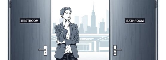 レストルーム」と「バスルーム」と書かれた2つのドアの間に人が立っている。.