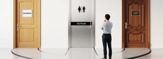 BATHROOM」「RESTROOM」「POWER ROOM」と書かれた3つのドアの前に立ち、どれに入ろうか迷っている様子の男。.